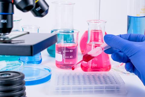 Scientist,Pipetting,Chemical,Liquid,Into,96,Well,Micro,Plate.,Examining