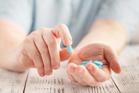 Male,Hand,Holding,Blue,Pills,In,Palm